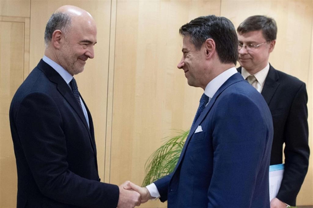 Stretta di mano tra il premier Conte e il Commissario Ue Moscovici (archivio Ansa)