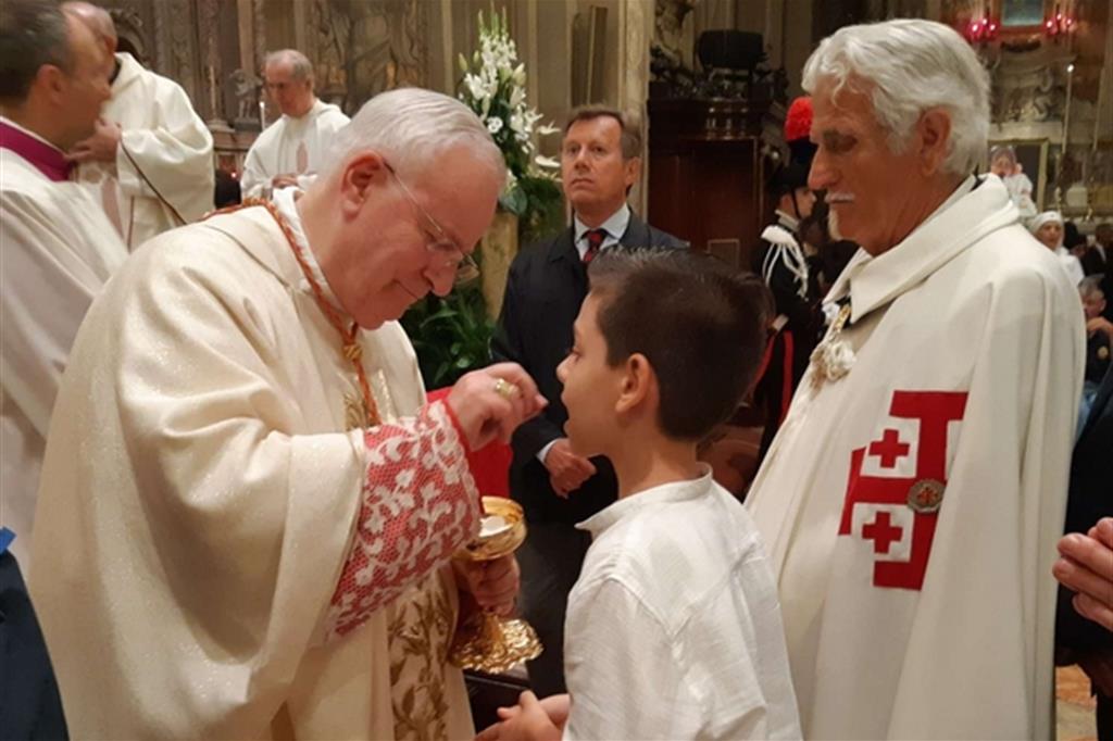 Il cardinale Gualtiero Bassetti dà la comunione a un ragazzino a Ferrara