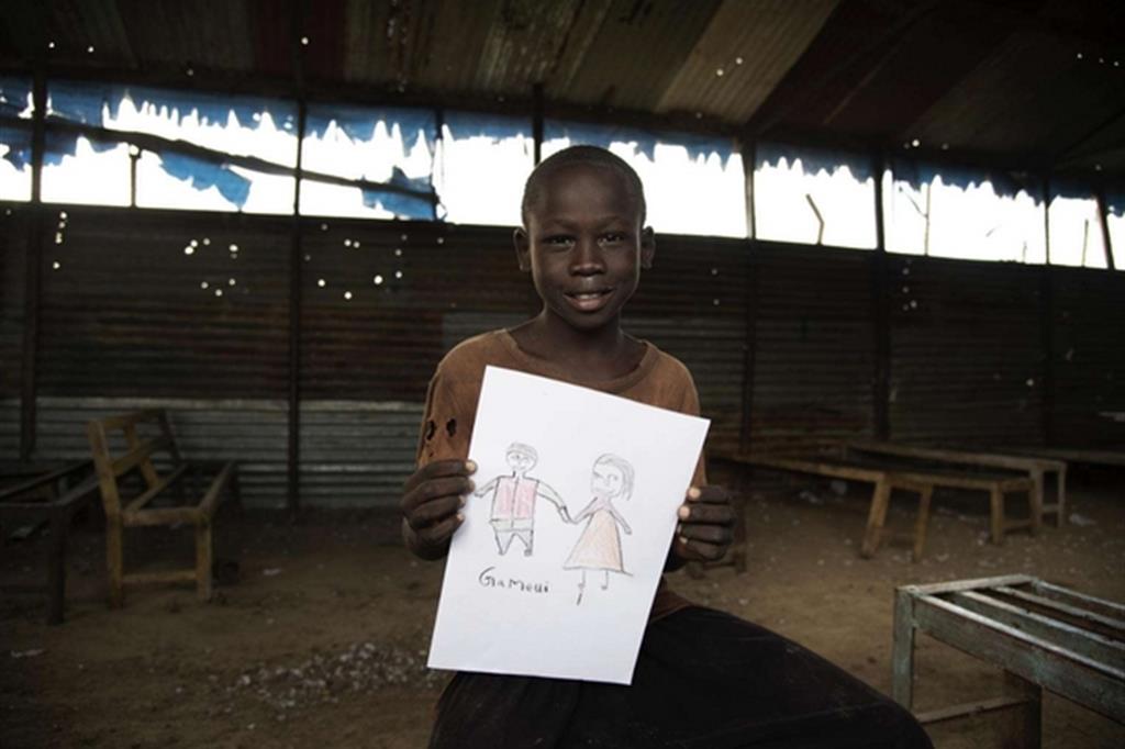 Jeremia Falluoch, 11 anni, mostra il disegno dei suoi genitori che non vede da 2 anni. Si sono separati durante un attacco armato. L'Unicef sta lavorando per rintracciarli (Foto Unicef)