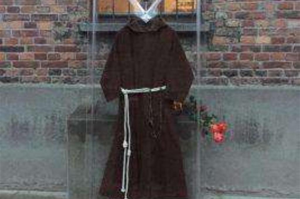 L'abito di san Pio da Pietrelcina custodito in una teca in plexigass di fronte alla parete del martirio di san Massimiliano Kolbe (foto:www.telepadrepio.it))