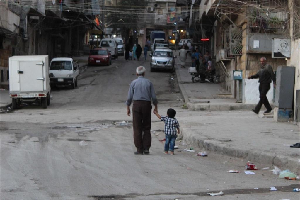 Nonno e nipote in una strada della parte Est della città di Aleppo bombardata durante l'assedio