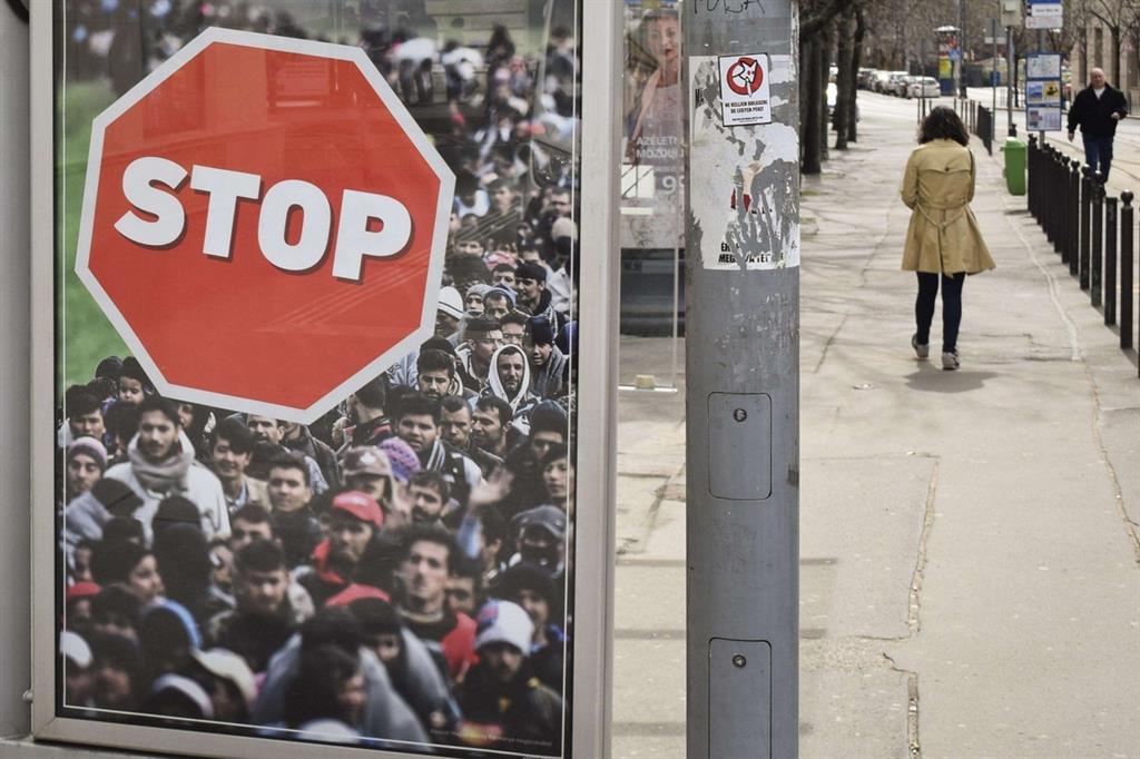 Budapest è tappezzata di manifesti contro i migranti: un cartello stradale con l'immagine dell'esodo di migliaia di disperati (Ansa)