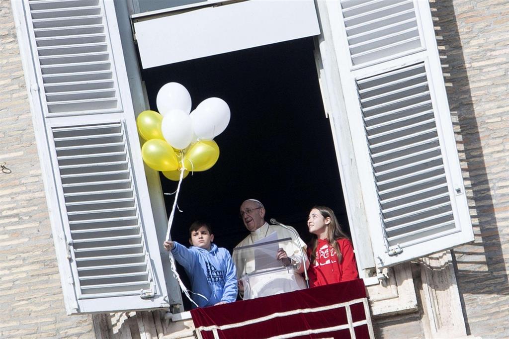 Il Papa ieri all'Angelus, con due bambini (Ansa)