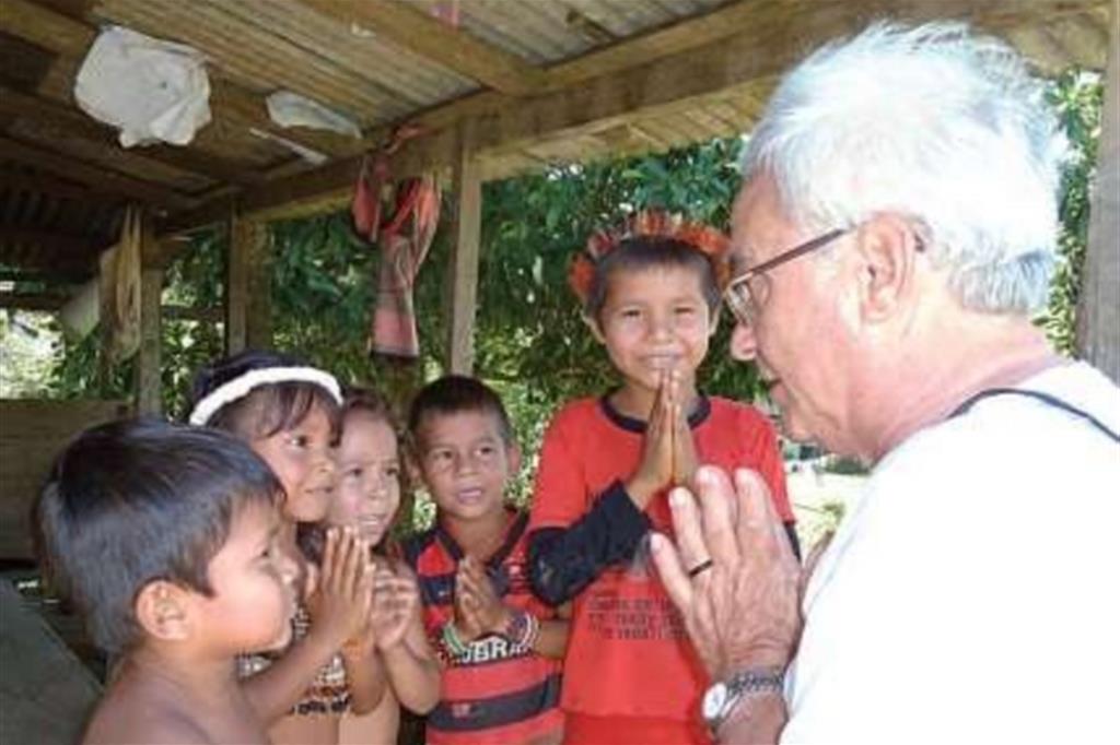 Padre Nello Ruffaldi, missionario del Pime in Amazzonia, prega con alcuni bambini (dal sito del Pime)
