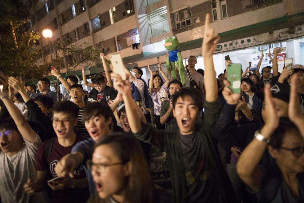 Sostenitori dei candidati anti-governativi esultano per il risultato delle elezioni distrettuali a Hong Kong (Ansa)