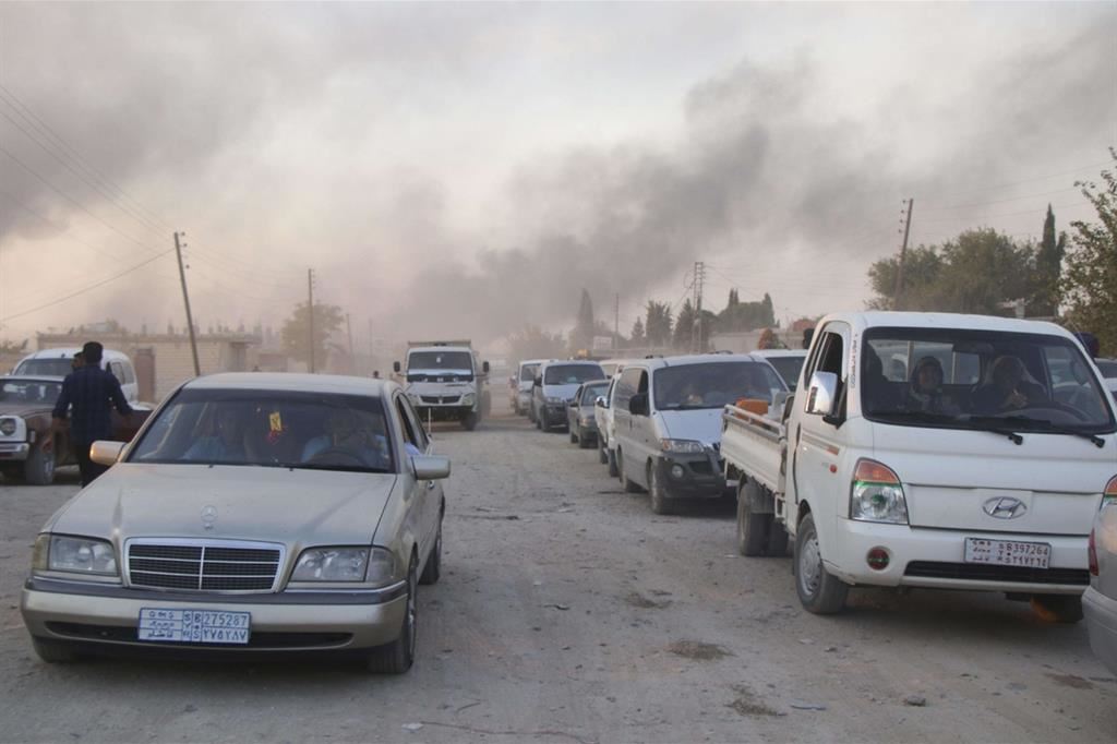Siriani in fuga dai bombardamenti dell'esercito turco a Ras al-Ayn (Ansa)