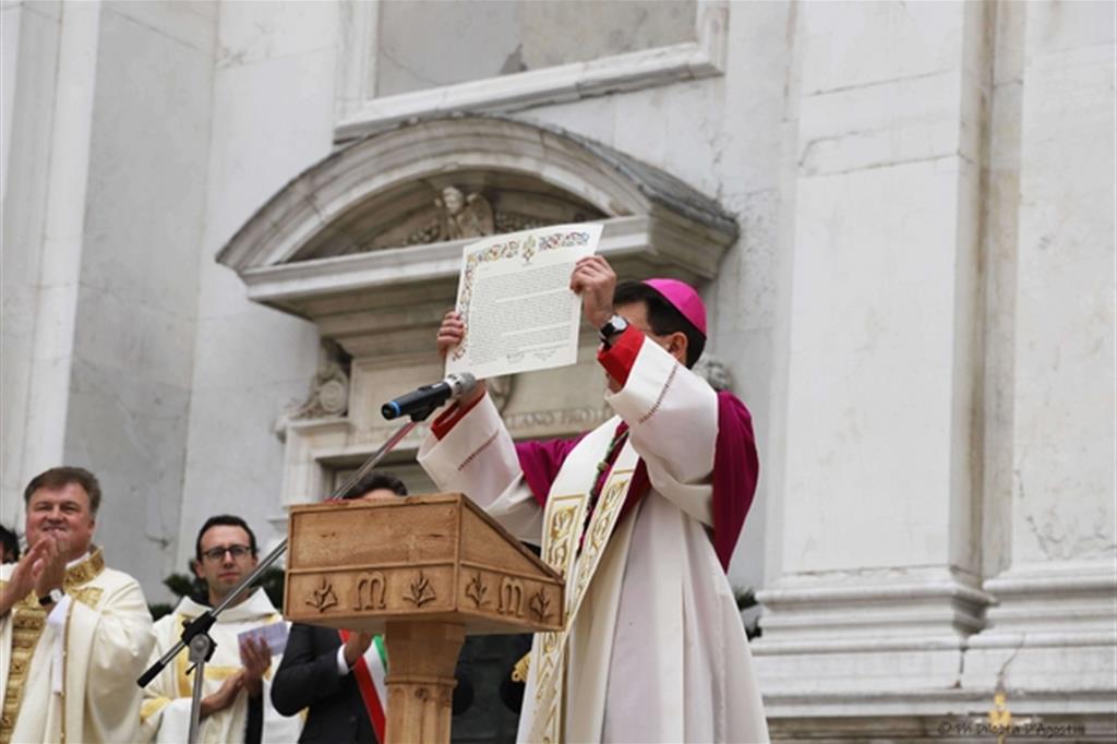 L'arcivescovo delegato pontificio mostra ai fedeli riuniti nella piazza davanti alla Basilica della Santa Casa, la bolla di indizione dell’Anno giubilare lauretano (foto Diletta D'Agostini)