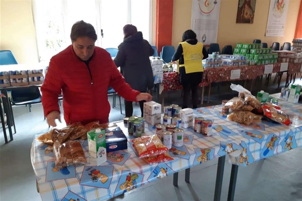 Bartolo Mercuri mentre appronta i viveri per i poveri sui tavoli all’interno del suo “emporio della solidarietà” a Maropati
