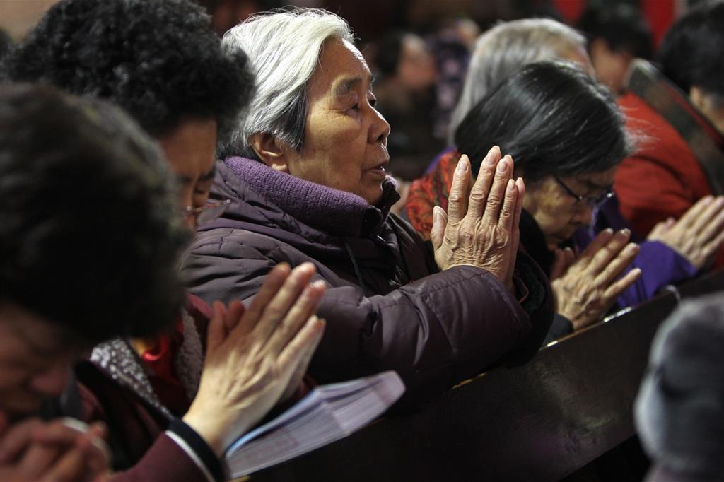 Cristiani cinesi in preghiera durante il Natale a Pechino (Ansa)