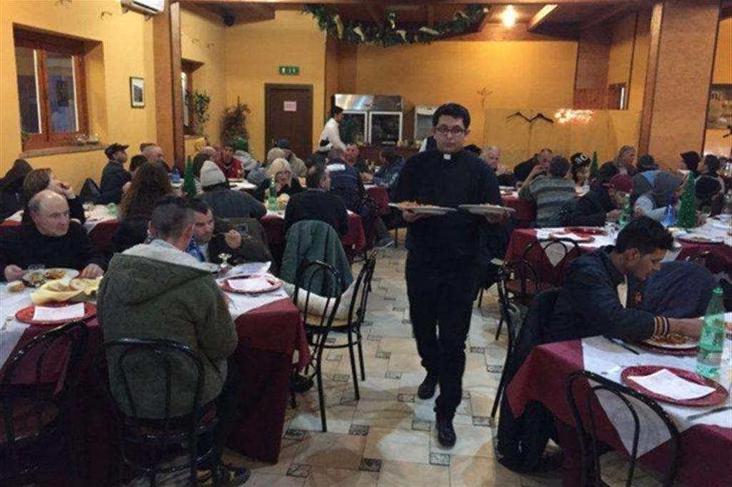 Un sacerdote serve a tavola alla mensa della Caritas di Latina (foto www.agensir.it)