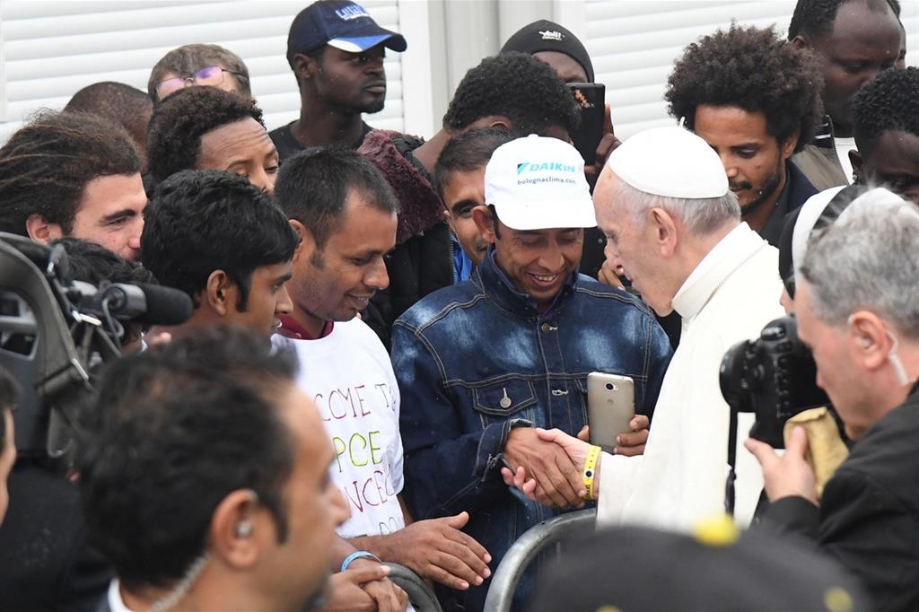 Il Papa con alcuni migranti in un'immagine d'archivio (Fotogramma)