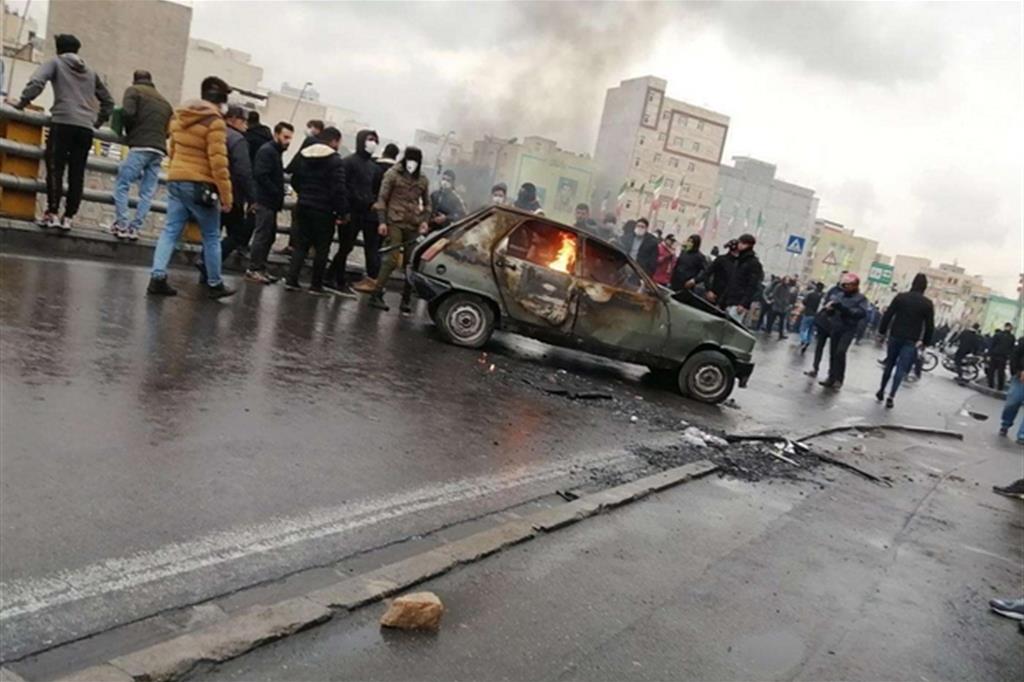 Un'auto in fiamme sull'autostrada durante le proteste a Teheran (Epa)