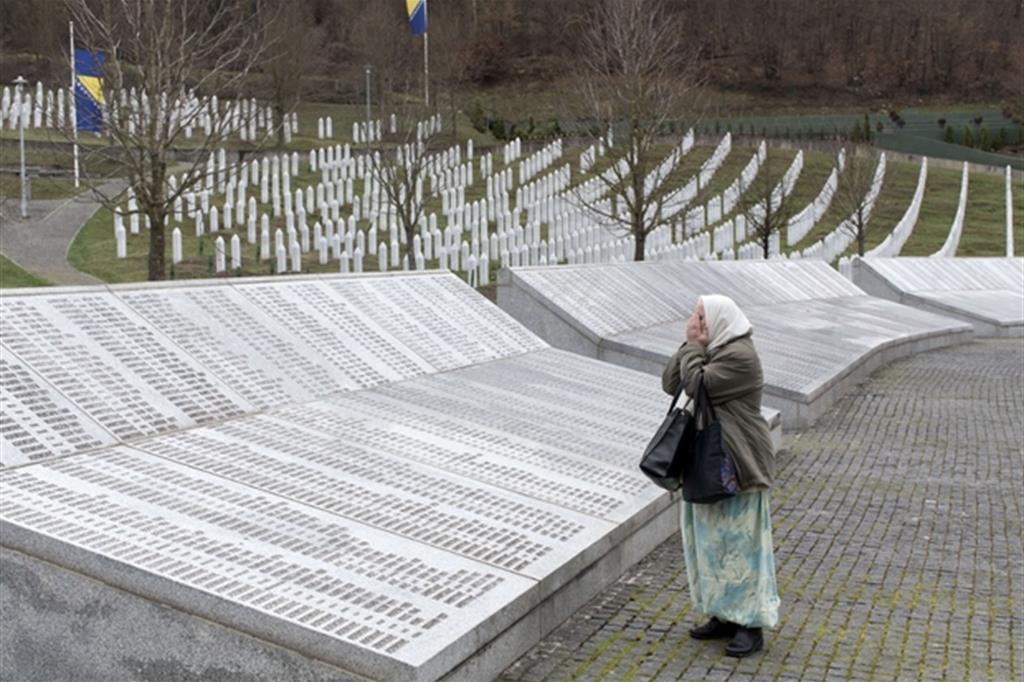 Una donna prega davanti al memoriale per le vittime del genocidio di Srebrenica a Potocari, in Bosnia ed Erzegovina (Ansa)