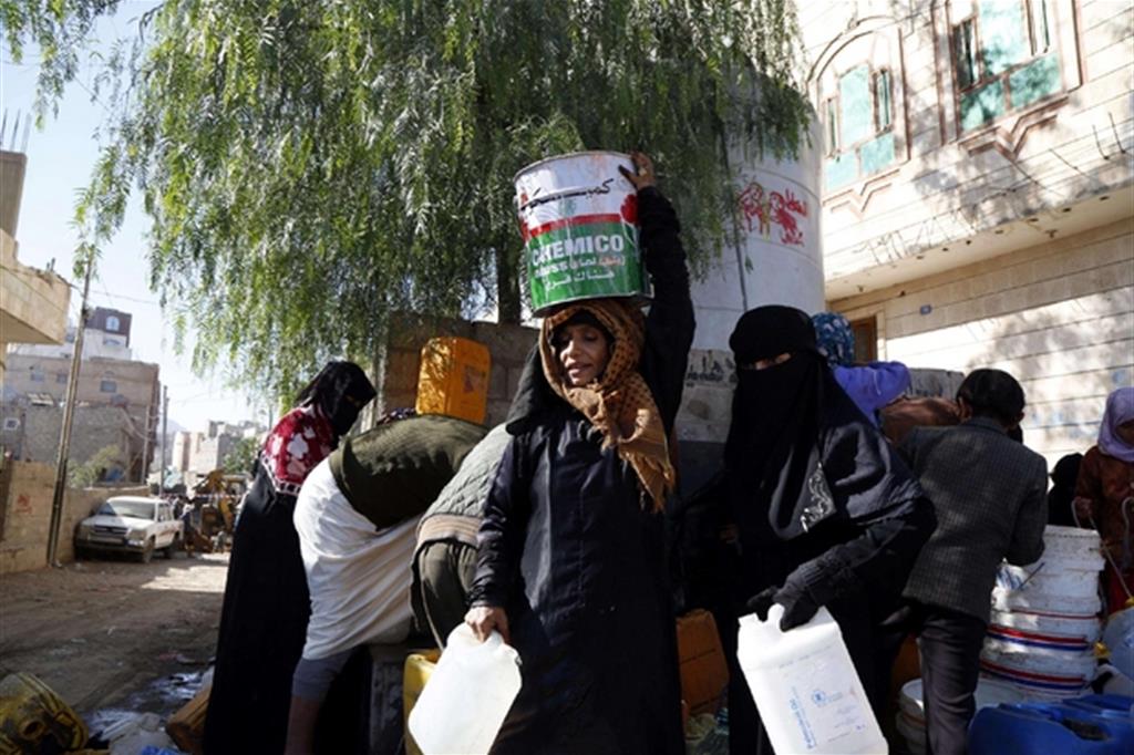 Donne fanno rifornimento di acqua in Yemen (EPA/YAHYA ARHAB)