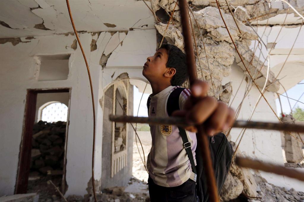 Un bambino yemenita tra le macerie di un'abitazione bombardata: la guerra dimenticata va avanti da quattro anni e sono i bambini a pagarne il prezzo più alto (Ansa)