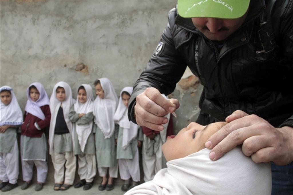 Bimbe pachistane in fila in attesa della somministrazione della dose  di vaccino contro la poliomielite  in un centro pubblico nell’area di Basti  nella capitale Islamabad (Ansa)
