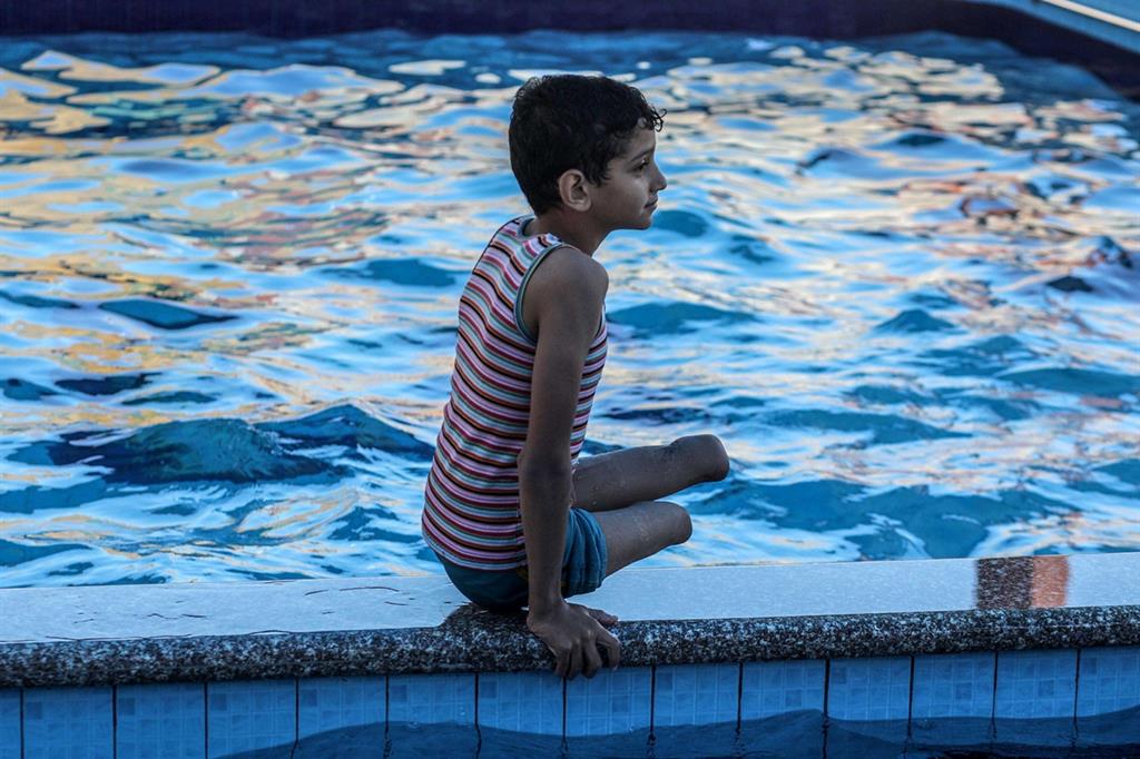 Wasem al-Shalouf, 9 anni, si riposa a bordo piscina (Ansa) - 