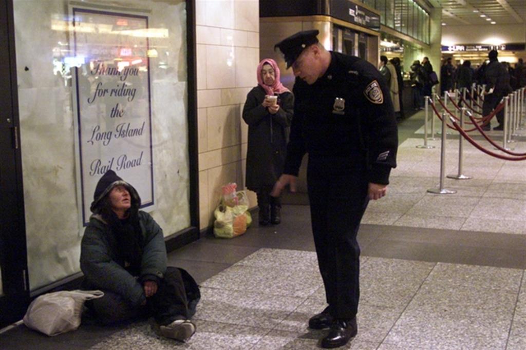 Poliziotto controlla una donna senza tetto a New York