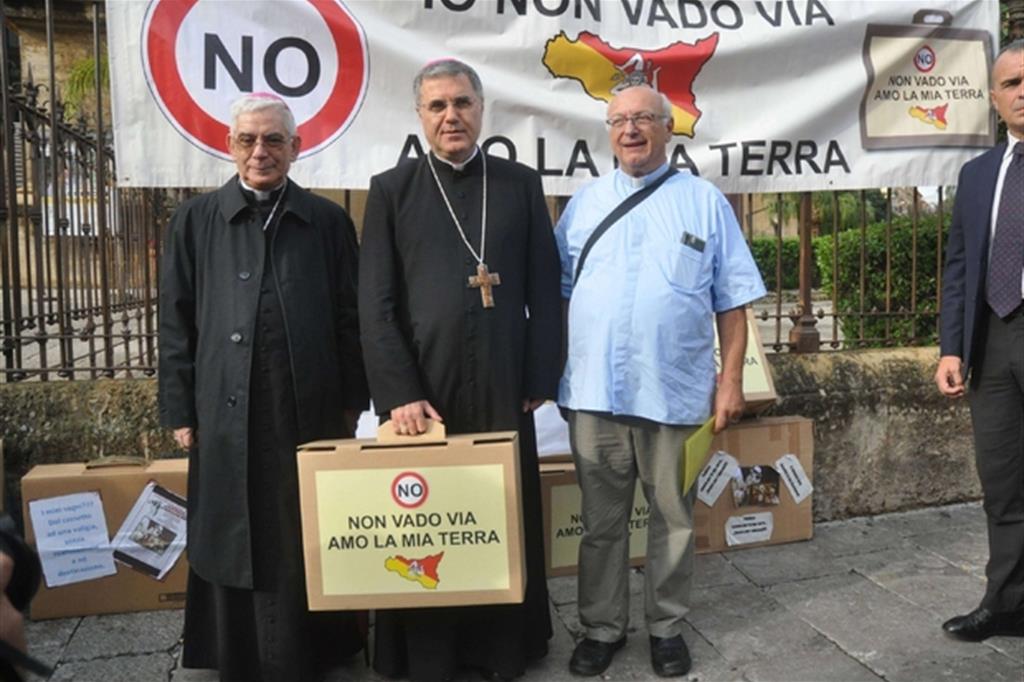 Monsignor Lorefice (con la valigia in mano) e monsignor Pennisi alla manifestazione di Palermo (Fotogramma)