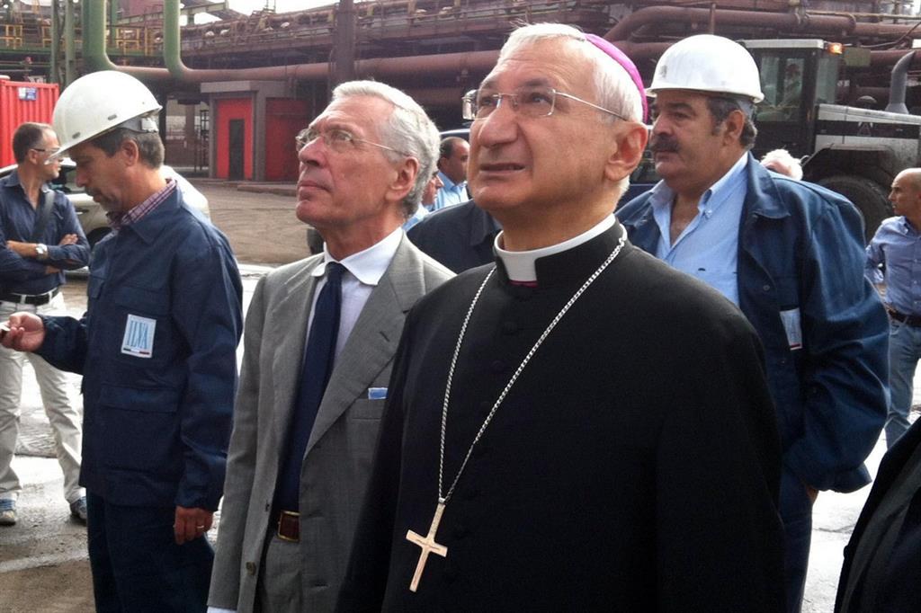 L'arcivescovo di Taranto, Filippo Santoro, in visita agli operai dell'Ilva in un'immagine d'archivio (Ansa)