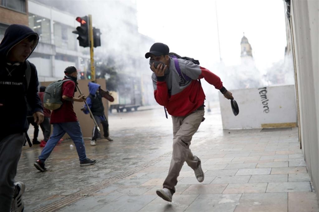 Gli scontri nella capitale Bogotà dove è stato decretato il coprifuoco notturno (Ansa)