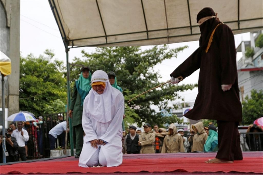 Un’esecuzione pubblica davanti alla grande moschea di Baiturrahman a Banda Aceh, capoluogo e centro più popoloso della regione speciale. La punizione viene inferta con un bastone di giunco: cento colpi equivalgono a cento mesi di prigione/ Ansa