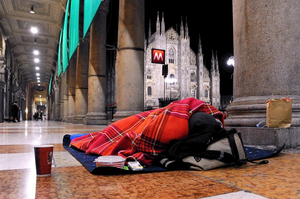 Milano: un clochard sotto i portici di piazza Duomo (foto di Maurizio Maule, Fotogramma)