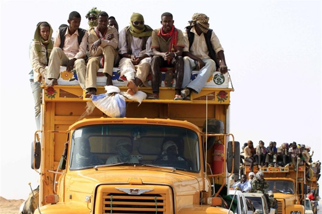 Un convoglio di migranti clandestini al confine tra Sudan e Libia in una foto di archivio, del 2014 (Ansa)