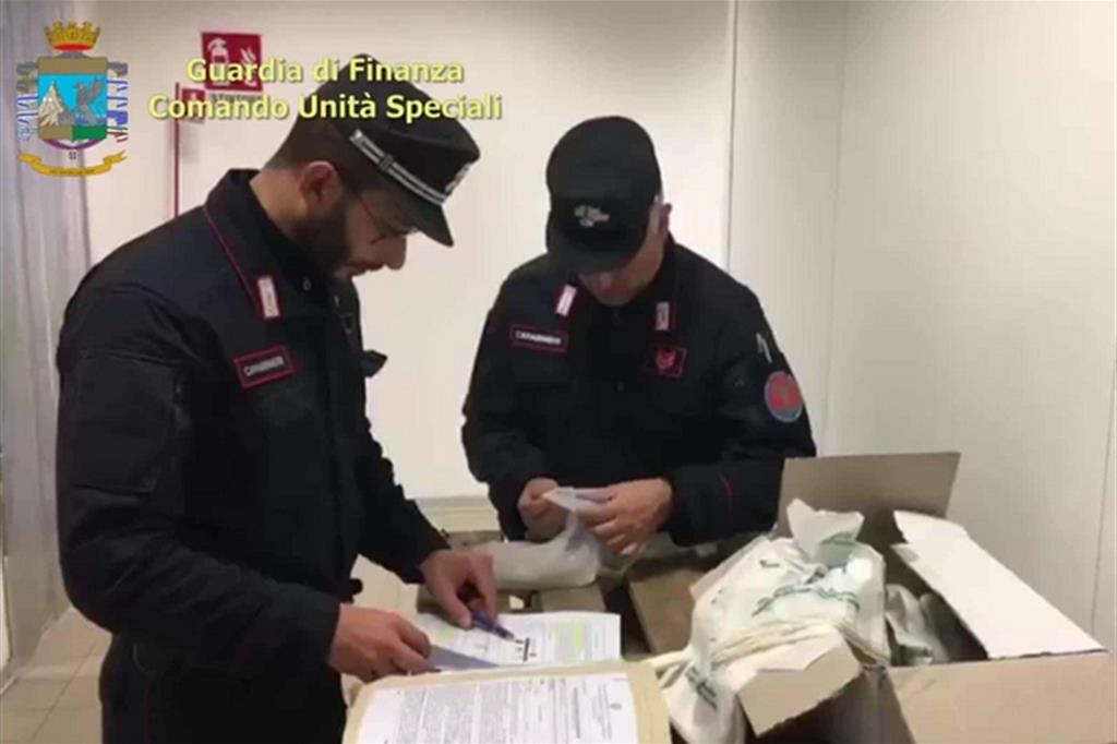 Due agenti durante uno dei tanti controlli che hanno portato al sequestro di oltre 2 milioni di sacchetti illegali, dannosi per l'ambiente (Ansa)