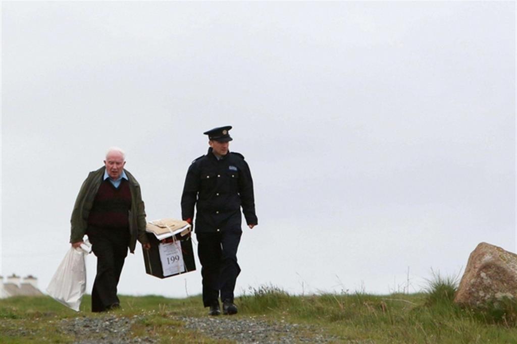 Il trasporto  di un’urna elettorale sull’isola  di Innishfree nella contea del Donegal  in Irlanda (Ansa)