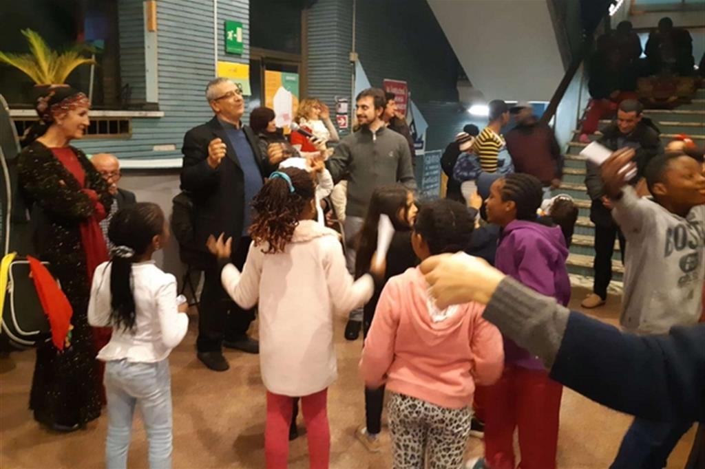 Il direttore della Fondazione Migrantes, don Gianni De Robertis, insieme alle famiglie nell’atrio del palazzo di via Santa Croce, a Roma