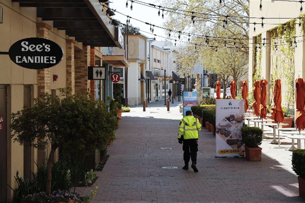 Una guardia controlla una desolata via dello shopping a Walnut Creek, California,