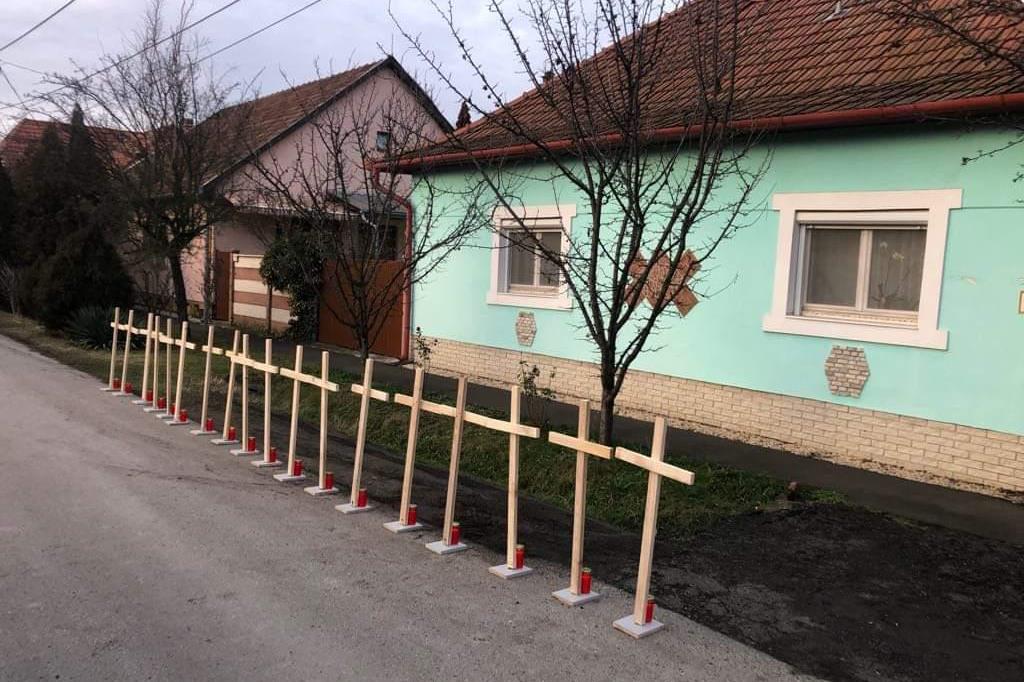Le 18 croci che ricordano le vittime dell'incidente davanti alla casa dell'autista ungherese del bus