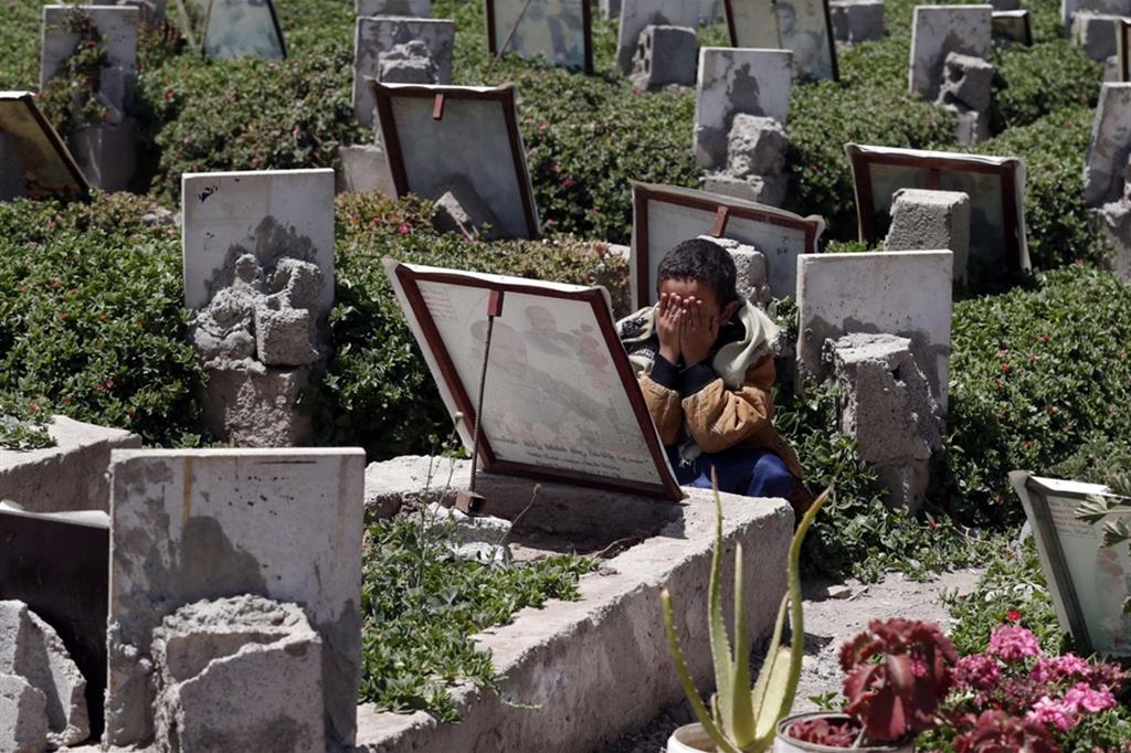 Bimbo prega sulla tomba del padre morto nel conflitto a Sanaa