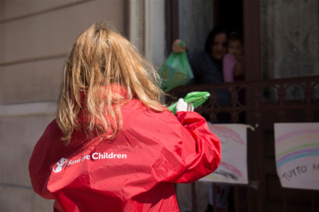 Brindisi, un'operatrice di Save the Children consegna pacchi di alimenti a una famiglia 