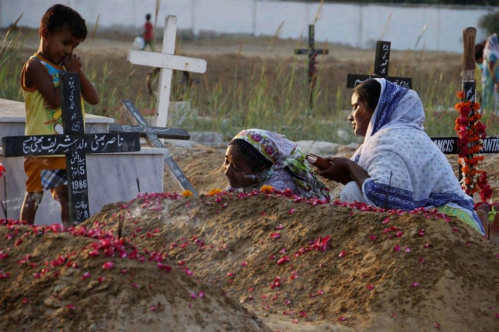 Cristiani in lacrime e in preghiera sulla tomba di un parente ucciso a Karachi in Pakistan