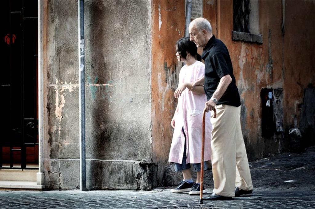 Una badante straniera accompagna un anziano