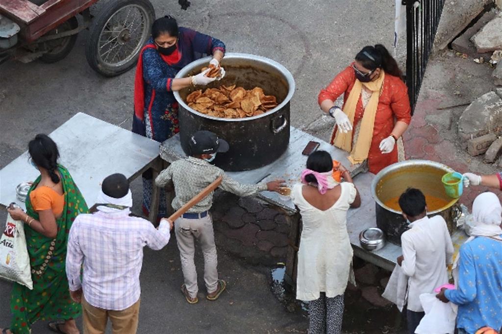 Volontari distribuiscono cibo a New Delhi