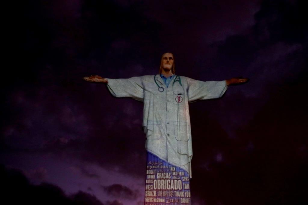 La statua del Cristo Redentore, alta 37 metri e posta sull'altura che sovrasta Rio de Janeiro, illuminata con un camice da medico - Reuters