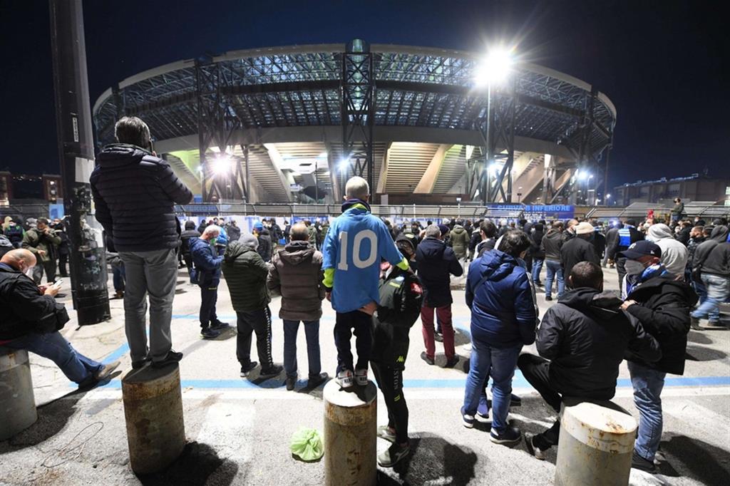 Tifosi napoletani davanti allo stadio San Paolo, rimasto illuminato per tutta la notte per rendere omaggio a Maradona