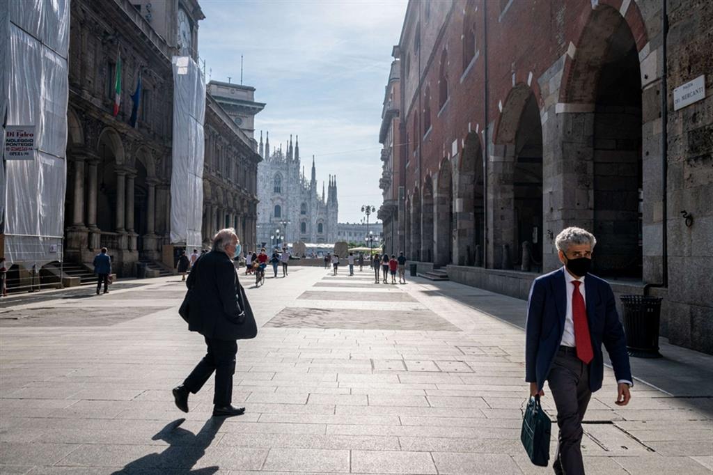 Persone camminano a Milano con la mascherina