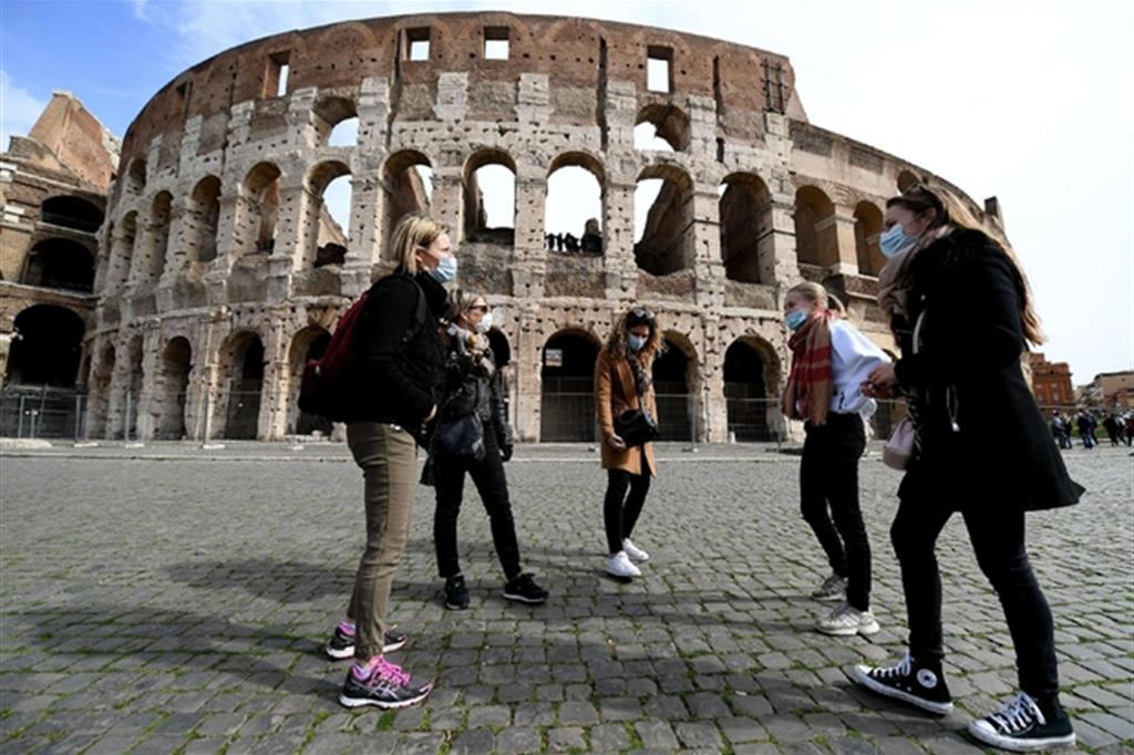 Giovani con la mascherina al Colosseo