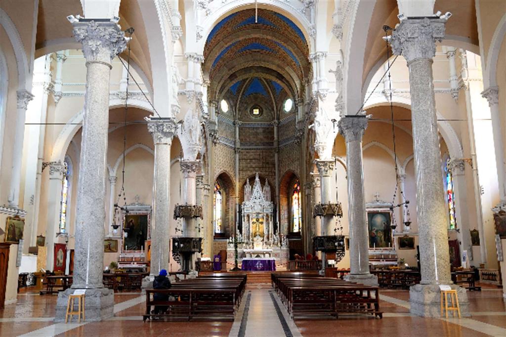 Pochi fedeli con la mascherano prega per la Settimana santa nella chiesa di Santa Maria delle Grazie al Naviglio, Milano