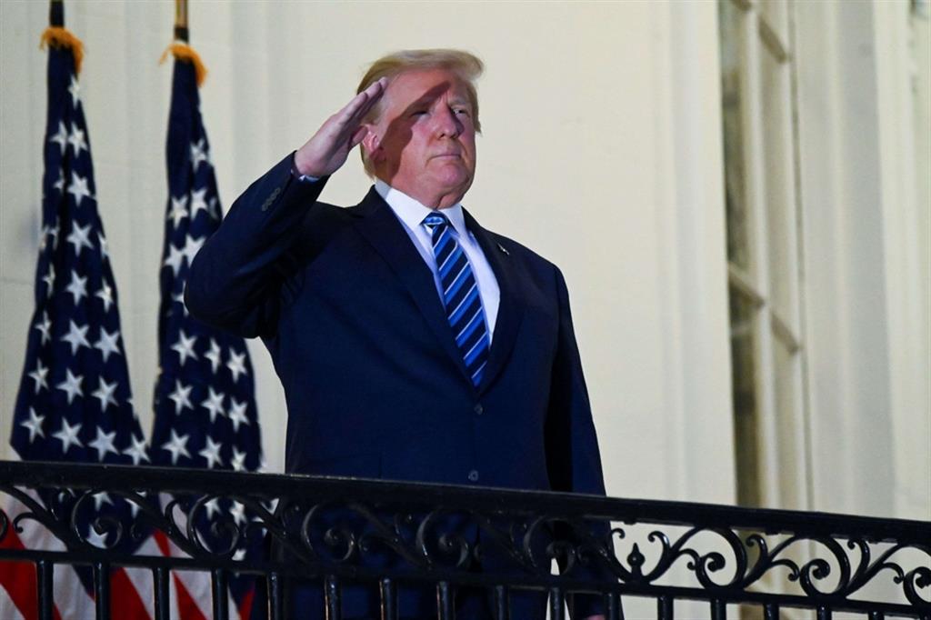 Il presidente Trump fa il saluto militare, dopo essersi tolto la mascherina, dal Truman Balcony della Casa Bianca appena dimesso dall'ospedale