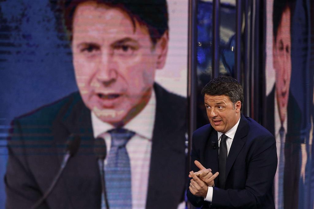 Il leader di Italia dei Valori Matteo Renzi e, alle sue spalle, l'immagine del premier Giuseppe Conte