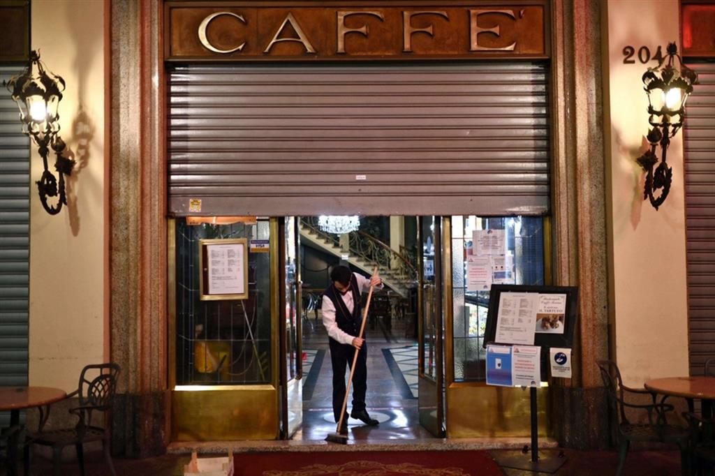Un cameriere del 'Caffe Torino', nel centro della città, si appresta a chiudere l’esercizio alle 6 del pomeriggio