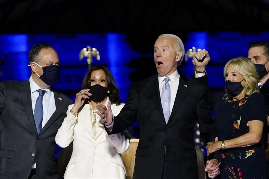 La notizia della vittoria di Biden, qui con la moglie, e di Kamala Harris, qui con il marito