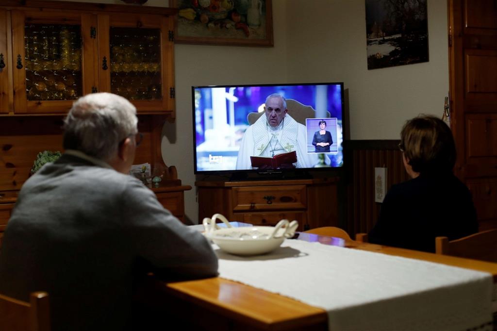 Una famiglia mentre segue in diretta tv la preghiera e la benedizione Urbi et Orbi di papa Francesco