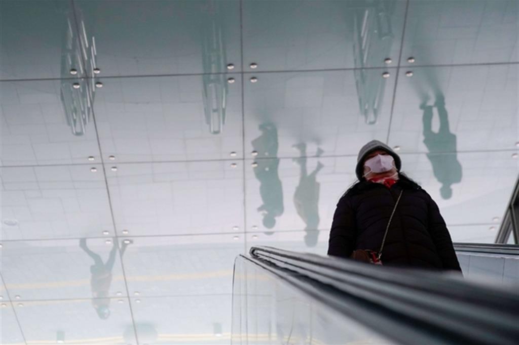 Una donna sulle scale mobili a Shangai. L'immagine della realtà può essere distorta e raccontata in modo interessato o falso