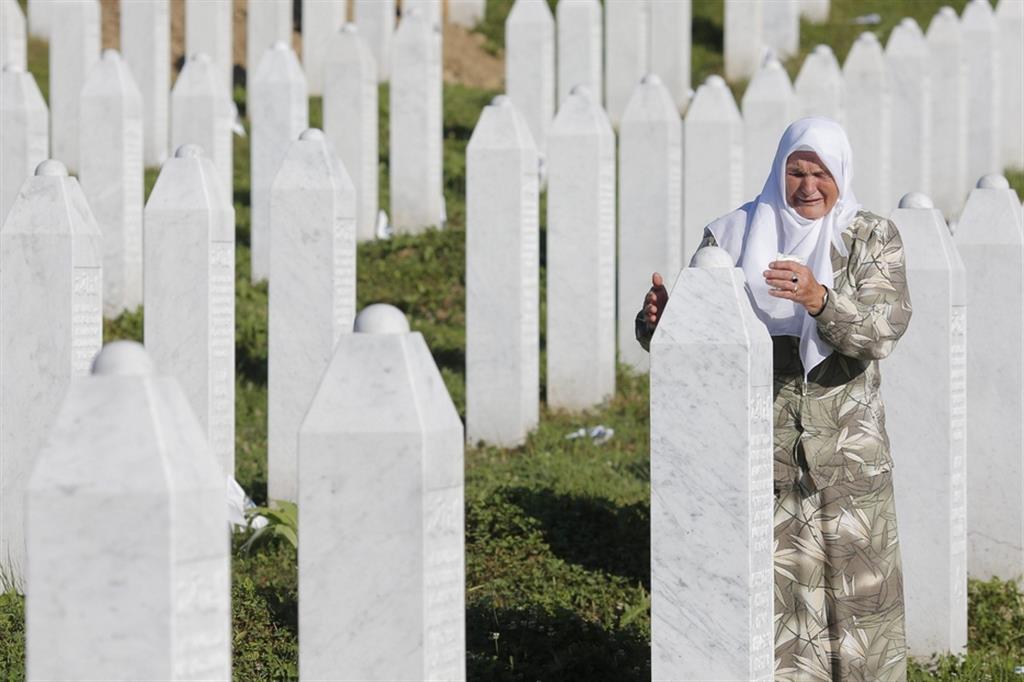 Una donna bosniaca piange sulla tomba di un suo caro a Srebrenica